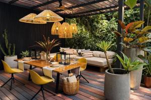 a patio with a table and chairs and plants at Exōtico Beach Hotel in Puerto Viejo