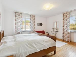 a bedroom with a large bed and two windows at Schwermann in Schmallenberg