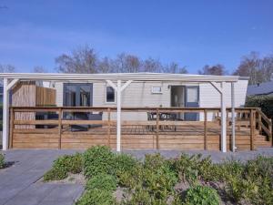a small white house with a wooden deck at t Kaatsheuveltje 7 in Kaatsheuvel