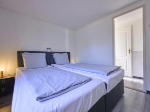 a bedroom with a large bed with white sheets at t Kaatsheuveltje 7 in Kaatsheuvel