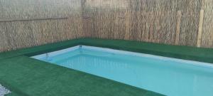 an empty swimming pool with a wooden wall and a blue at Cascina Danila in Narzole