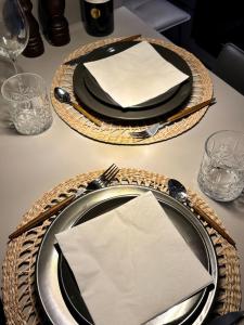 a table with a black plate with a white napkin at DESIGNBUTZE by BUTZENFLOTTE Grömitz - Beach Loft & Meerblick in Grömitz +22 photos