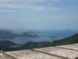 uma vista para uma massa de água de uma montanha em Jiufen Hui Ming Homestay em Jiufen