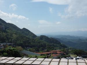 uma vista para um vale com montanhas ao fundo em Jiufen Hui Ming Homestay em Jiufen