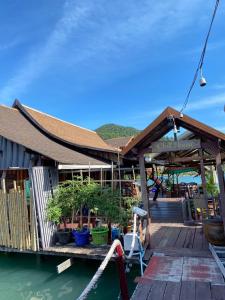 a building on a dock with potted plants on it at Chill House kohchang in Ban Bang Bao