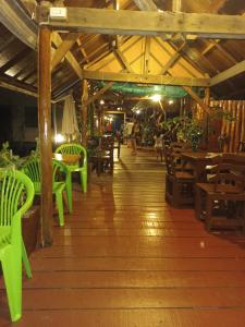a restaurant with green chairs and tables and a wooden floor at Chill House kohchang in Ban Bang Bao