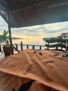 a wooden table with a view of the water at Chill House kohchang in Ban Bang Bao