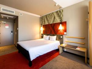 a hotel room with a large bed and a table at Ibis Wroclaw Centrum in Wrocław +125 photos
