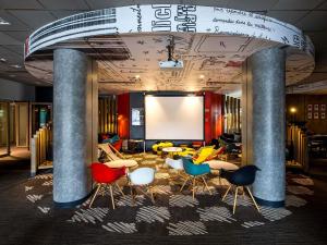 a meeting room with colorful chairs and a projection screen at Ibis Wroclaw Centrum in Wrocław