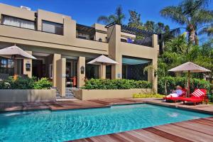 a villa with a swimming pool in front of a house at The Residence in Johannesburg