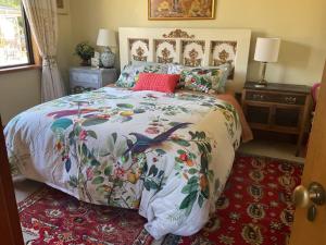 a bedroom with a bed with a colorful comforter at Redwood Valley B & B in Richmond