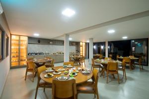 a dining room with tables and chairs and a kitchen at Casa do Valle Hotel Boutique - Vale do Capão in Vale do Capao