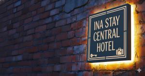 a sign on the side of a brick wall at -Ina Stay Central Hotel-8名宿泊可 伊那市駅徒歩5分 駐車場無料 a sleep8-a 5minute walk from the station-Free parking in Ina