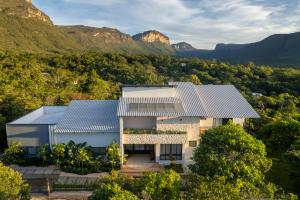 an aerial view of a building with mountains in the background at Casa do Valle Hotel Boutique - Vale do Capão in Vale do Capao