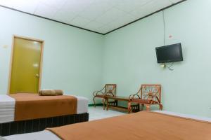 Ein Zimmer mit zwei Betten und einem Fernseher an der Wand. in der Unterkunft Hotel Antik in Soreang