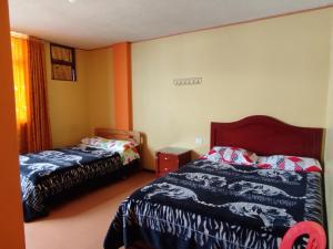 a bedroom with two beds and a window at Hotel atahualpa in Pasto