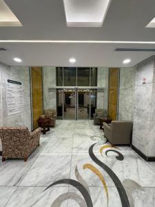 a lobby with couches and chairs in a building at فندق الروضة المتحدة Hotel AL Rawdah United in Al Khansāk
