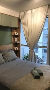 a bedroom with a bed with a large window at Studio Centro Curitiba in Curitiba