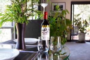 a bottle of wine sitting on a table with glasses at A Heavenly Escape in Halls Gap