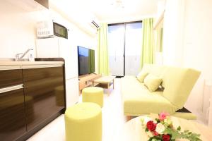 a small living room with a couch and a kitchen at The Grand Win in Fukuoka