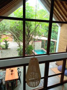 a room with a large window with a hanging light at Casa Flora Ayampe in Ayampe