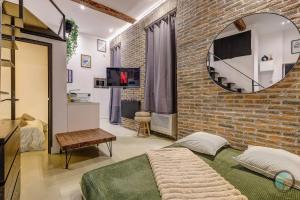 a bedroom with a brick wall and a mirror at Chic Industrial Loft Quiet Garibaldi AC Balcony in Nice
