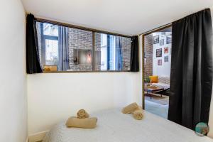 a bedroom with a bed with two animal pillows on it at Chic Industrial Loft Quiet Garibaldi AC Balcony in Nice