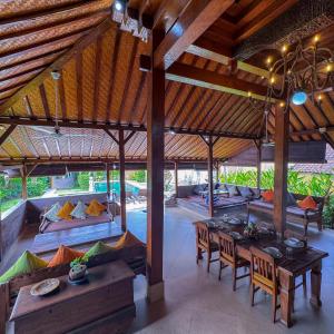 a large room with a table and chairs and a bedroom at Bali Dyana Villas in Seminyak