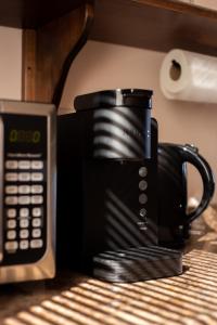 a black coffee cup sitting on top of a microwave at Villas Persas by Jardin de Persia in Valle de Guadalupe