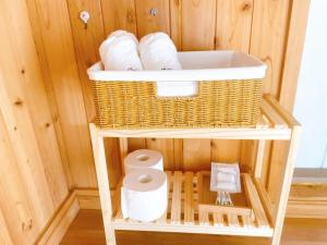 a bathroom with a toilet and a basket on a shelf at Wando Haegeum Pension in Wando