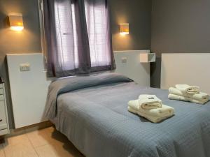 a bedroom with two towels on a bed at HOTEL EL VIEJO Bar in Perito Moreno +62 photos