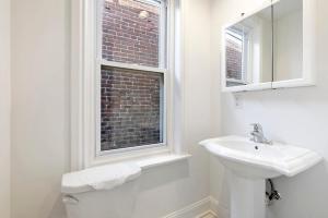 a white bathroom with a sink and a window at Candlelight Chamber - Private Room with Shared Space in Chester +5 photos