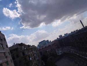 a city with tall buildings and a cloudy sky at Arabesque Hotel in Cairo