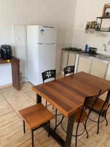 a kitchen with a wooden table and chairs and a refrigerator at Casa vila carolla in Tiradentes