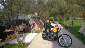 a man sitting on a motorcycle in front of a house at Hotel River View bihac in Lohovo +42 photos