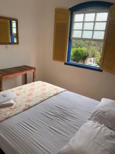 a bed in a bedroom with a window at Casa vila carolla in Tiradentes
