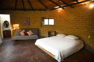 ein Schlafzimmer mit einem Bett und einer Ziegelwand in der Unterkunft Hangar 5 in San Lucas del Pulque + 7 Fotos