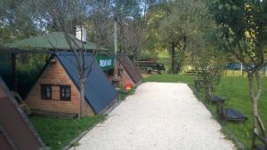 a log cabin with a walkway in a park at Hotel River View bihac in Lohovo