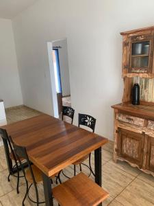 a dining room with a wooden table and chairs at Casa vila carolla in Tiradentes +8 photos