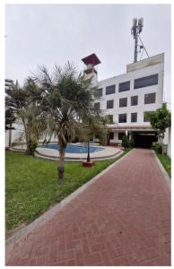 a building with palm trees in front of a sidewalk at Modern Apartament Pool & Jacuzzi 2 room in Lima