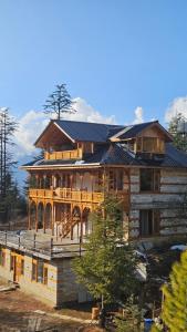 a large wooden house with a gambrel roof at Himalayan Baseraa in Sainj