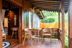 a dining room with a table and chairs on a porch at Umah Jati Villa in Gianyar