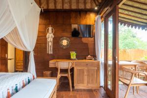 a bedroom with a desk and a bed in a room at Umah Jati Villa in Gianyar