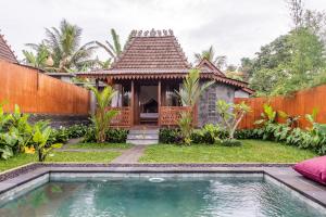 a house with a swimming pool in front of a house at Umah Jati Villa in Gianyar