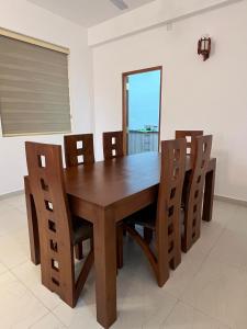 a dining room with a wooden table and chairs at EZ Colombo Stay in Colombo