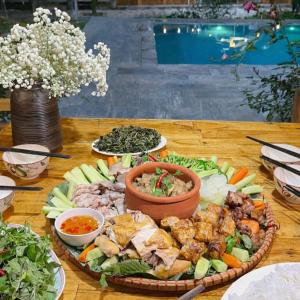 a table with a plate of food on a table at Bon Ben Homestay in Hòa Bình +30 photos