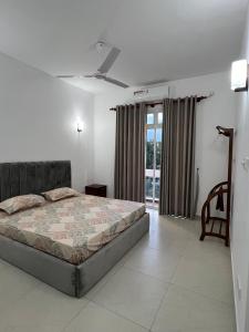 a bedroom with a bed and a large window at EZ Colombo Stay in Colombo