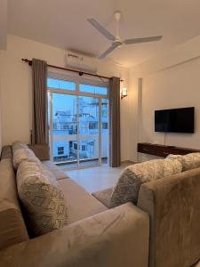 a living room with a couch and a flat screen tv at EZ Colombo Stay in Colombo