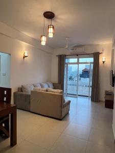 a large living room with a couch and a balcony at EZ Colombo Stay in Colombo +3 photos