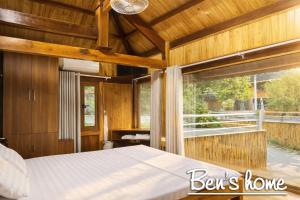 a bedroom with a bed and a large window at Bon Ben Homestay in Hòa Bình